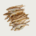 Load image into Gallery viewer, A wooden plate full of Freeze-Dried Capelin Fish from Arya! Sit. Overhead view, to show full detail. 4"-5" long fish are whole, and look similar to dried smelt.