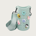 Load image into Gallery viewer, A mint green silicone cup sleeve with a matching nylon shoulder strap, decorated with cute cartoon charms including a bunny, dog, sheep, cat, and penguin.