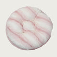 Load image into Gallery viewer, Round, plush pet bed made with faux fur in shades of pink and cream in a subtle striped pattern.