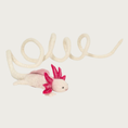 Load image into Gallery viewer, Side view of the wool axolotl toy, showing its full body with its cream colored tail coiled and slightly extended.