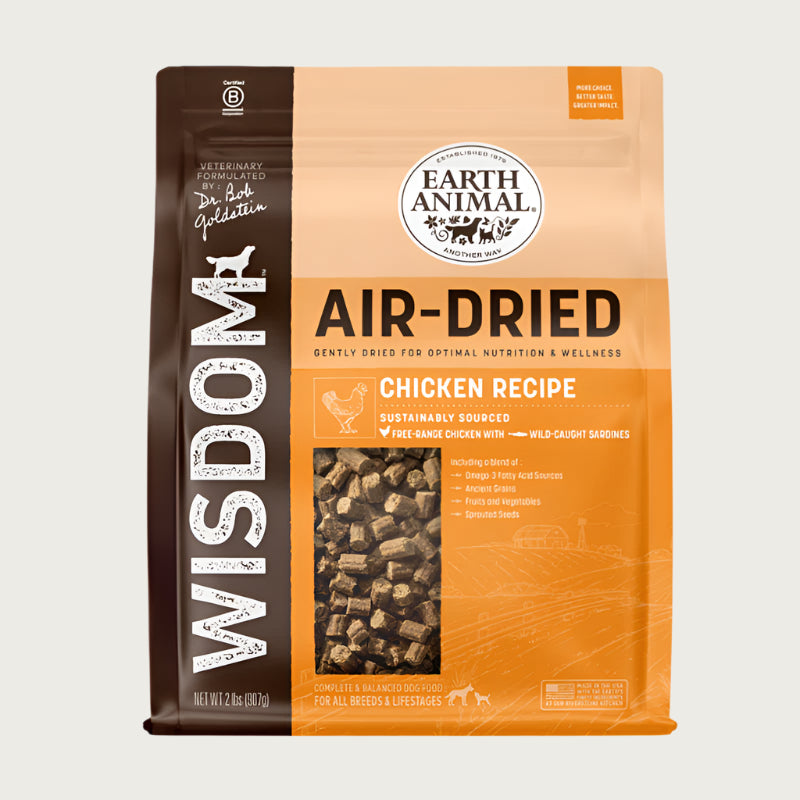 An orange and brown bag of Wisdom Air-Dried Chicken Recipe dog food. Complete & balanced for all breeds & lifestages. Small transparent window shows actual dog food inside (small, rectangular brown bites).