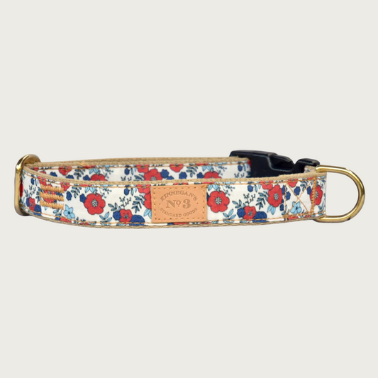 Red and blue floral patterned dog collar with a brass D-ring and black plastic buckle.