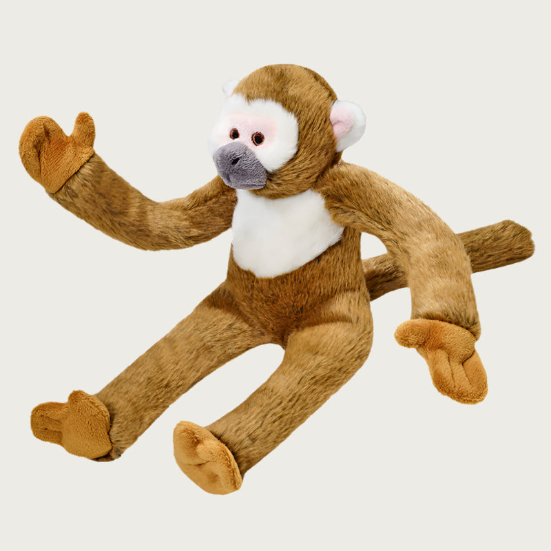 Plush Albert Monkey dog toy from Fluff & Tuff. This "squirrel monkey" toy is a medium brownish color, with white accents on its chest, face and ears, and long arms, legs and tail.
