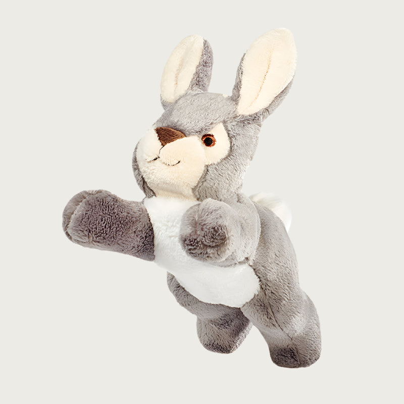 Plush Jessica Bunny dog toy from Fluff & Tuff. Its front and back legs are outstretched, and its body is a warm gray, with cream tummy, tail, muzzle and inner ears.