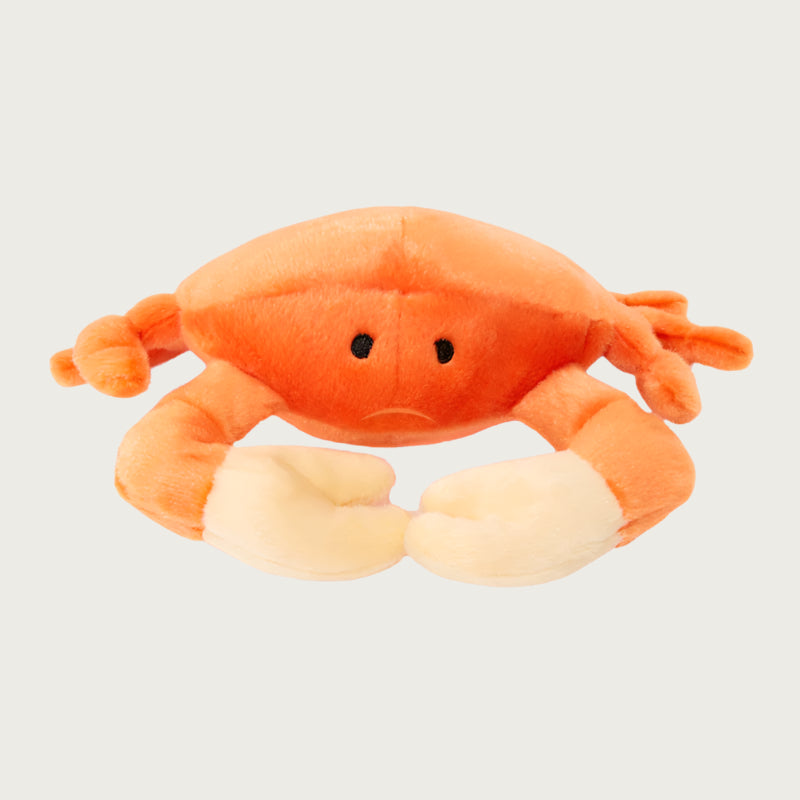 Plush Phyllis Crab dog toy from Fluff & Tuff. Toy has an orange body and eight legs,with pale yellow pincers on its front two legs, and black eyes.