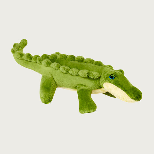 Plush Savannah Baby Gator dog toy from Fluff & Tuff. Toy looks like a baby alligator. It is a medium shade of green on top, and underneath it is pale yellow, with blue eyes.