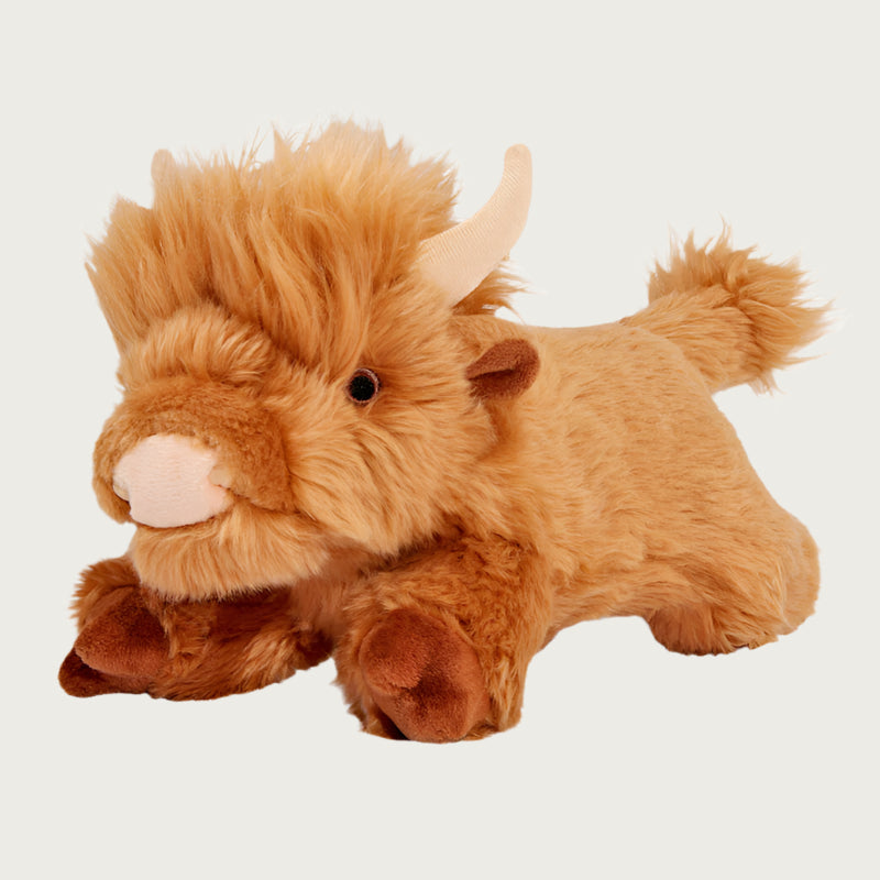 Plush Shaggy the Highland Cow dog toy from Fluff & Tuff. Toy is a light reddish brown color, with extra long plush around the head and tail. It has beige colored horns and nose.