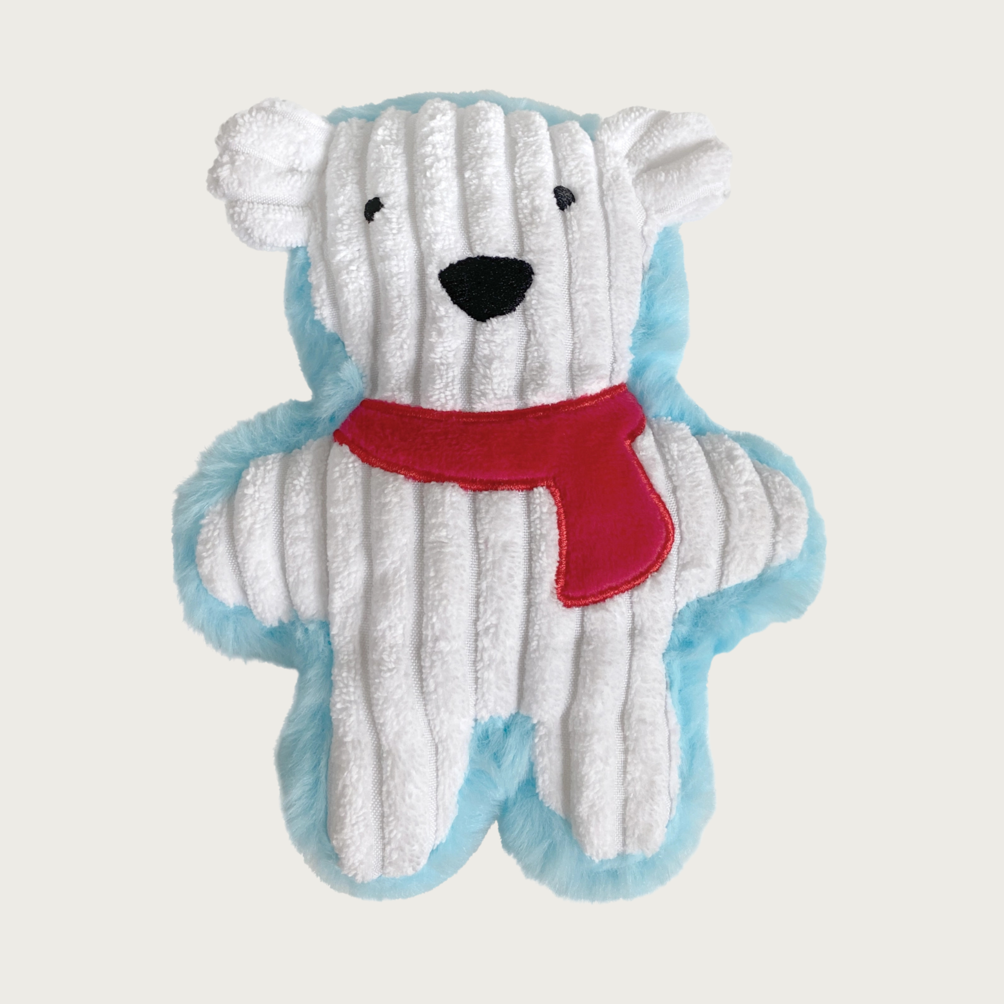 Plush dog toy shaped like a small polar bear standing up, with a white corduroy body trimmed in light blue plush, and wearing a red scarf. Embroidered eyes & nose detail in black.