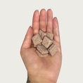 Load image into Gallery viewer, Hand holding small square Goat Milk Biscuit dog treats.
