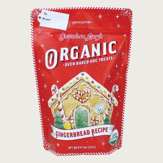 Red bag of Limited Edition Grandma Lucy's Organic Oven Baked Dog Treats Gingerbread Recipe with gingerbread house design in center of bag. USDA Organic.
