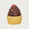 Load image into Gallery viewer, Mini latex cupcake dog toy. It has a light yellow base, with brown frosting on top. It has multi-colored sprinkles on the frosting, with a red cherry on top, and sweet, simple, smiley face in black, centered on the front.