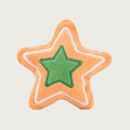 Load image into Gallery viewer, Star shaped plush dog toy, designed to look like a decorated sugar cookie. It is beige, with a smaller green star in the center, and a white line outline along the toy's edges.