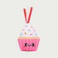 Load image into Gallery viewer, Cupcake shaped plush cat toy. It has a bright pink base with a smiling face and white "frosting" with sprinkles. There are short, red & white ribbons coming out of the top.