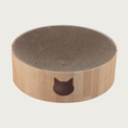 Load image into Gallery viewer, Round cat scratcher with faux oak wood colored exterior and corrugated cardboard interior. Simple cat face silhouette in brown is on the front.