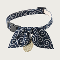 Load image into Gallery viewer, Cat collar with a dark navy blue background and white curly-q pattern, with a simple bow in the same pattern. It has a dangling gold tone Asian-inspired charm and black plastic clip & slider.
