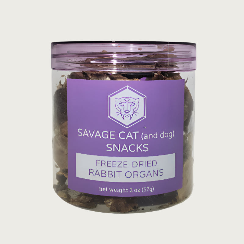 Clear plastic container with a purple tint & label, with reddish brown chunks of freeze-dried rabbit organs inside.