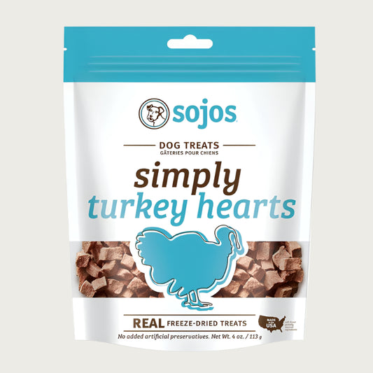 A 4 oz white and teal blue bag of Sojos Simply Turkey Hearts Dog Treats. No added artificial preservatives. See-through window at the bottom of the bag shows product inside - very small, cube shaped brown treats.