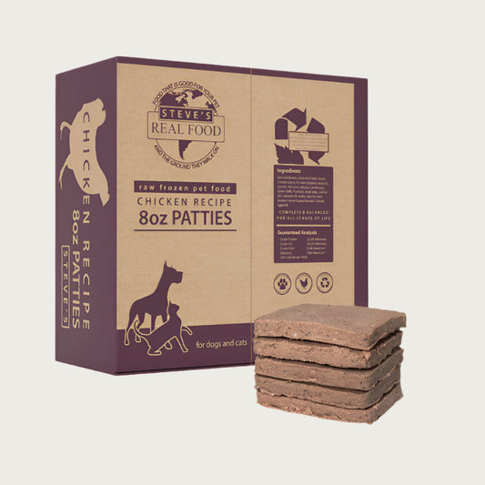 A 14 pound box of Steve's Real Food frozen raw food 8 ounce patties in the chicken recipe for both dogs and cats. A plate of the bar shaped patties is positioned in front of the box for reference.
