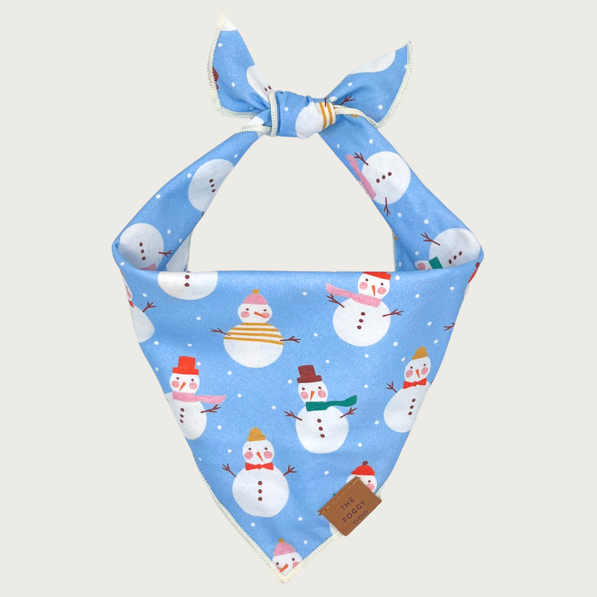 Light blue dog bandana with snowman print, with tiny white dots that look like snow. The snowmen are all wearing different colored scarves and hats.