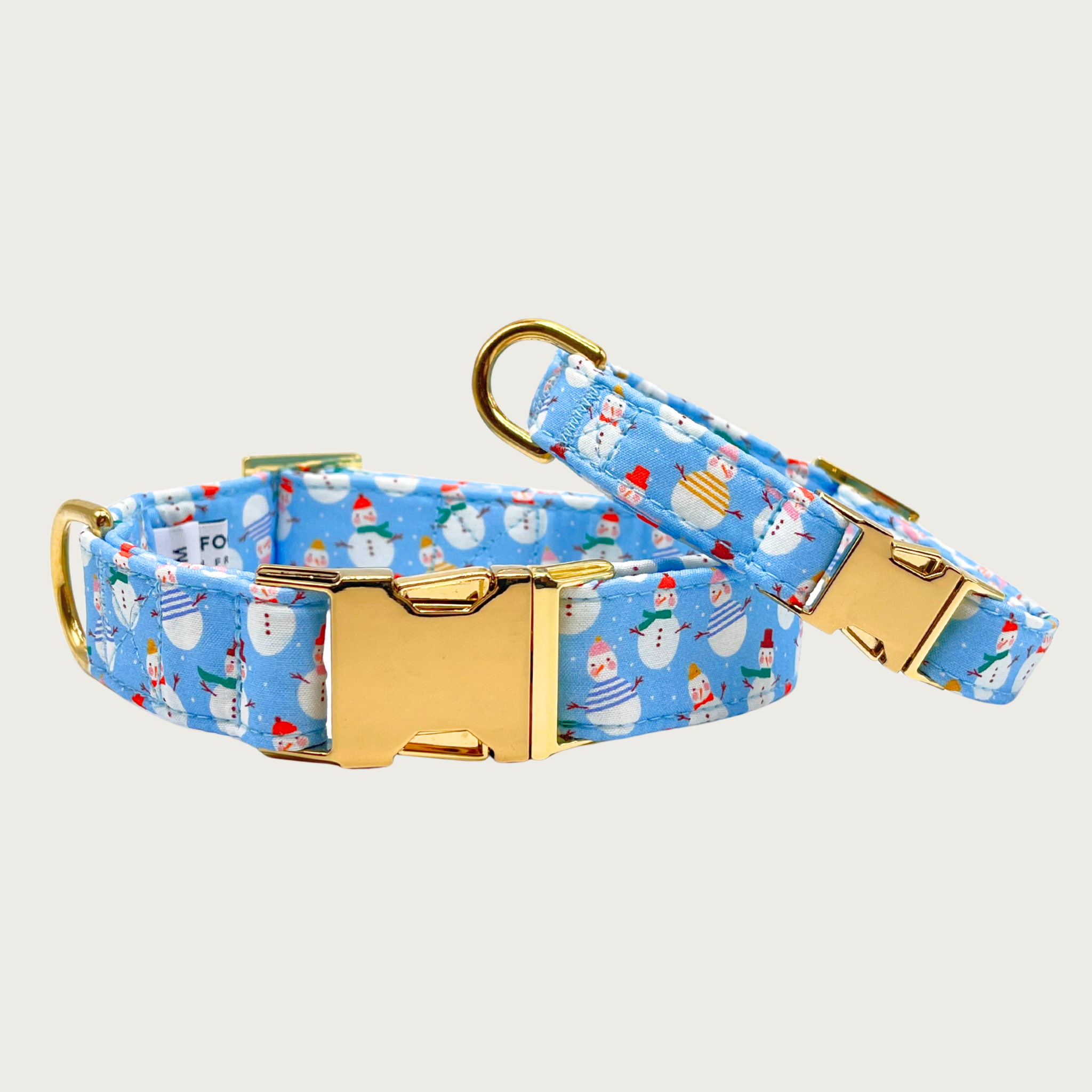 Pair of Frosty Friends dog collars; 5/8" wide collar leaning on the 1" wide one, to show the size difference.
