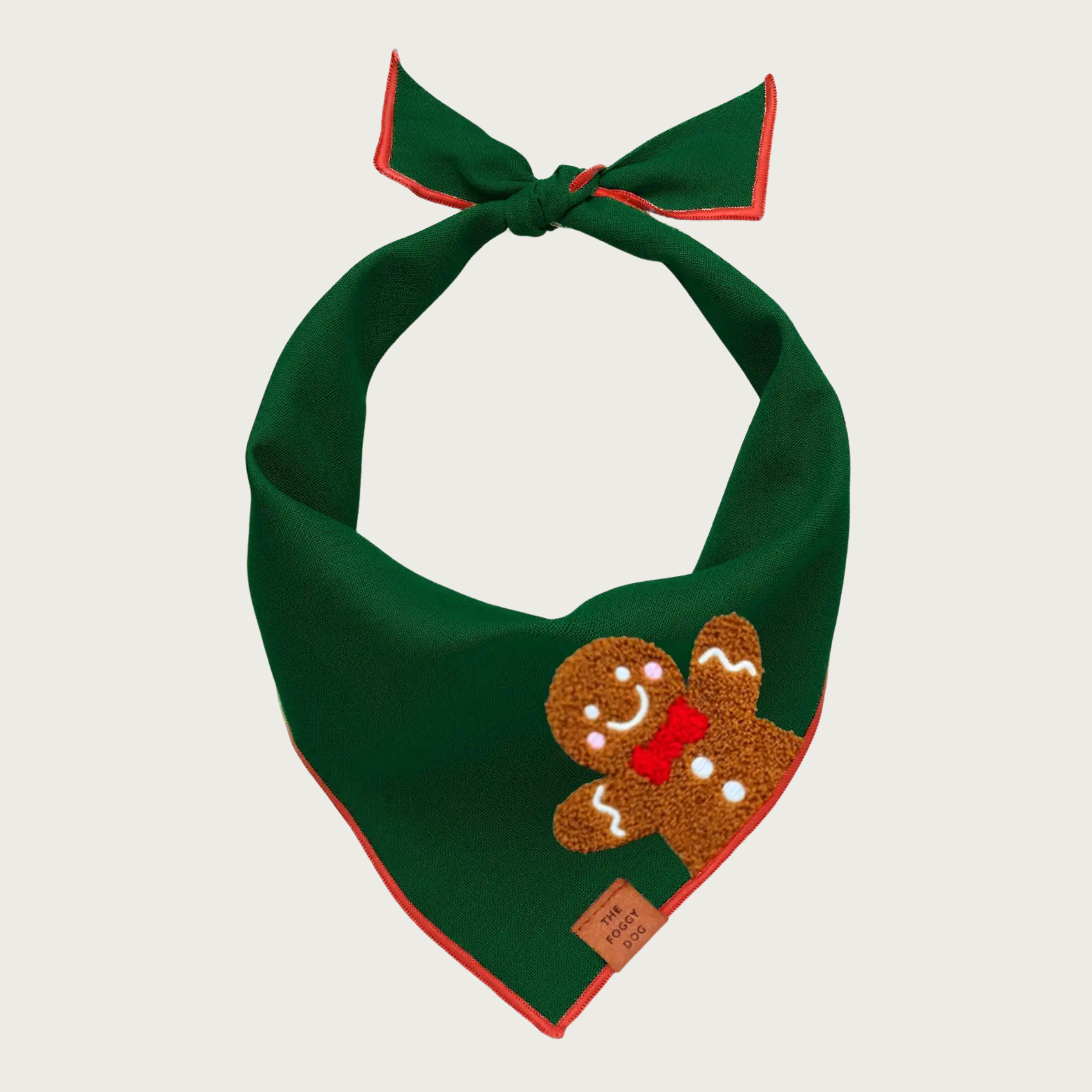 Dark green bandana with red trim and appliqued smiling gingerbread man on its left side.