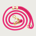 Load image into Gallery viewer, Coiled, hot pink rope dog leash with brass hardware. Fastened on both ends with brass clamps, instead of stitching. O-ring is in the handle part of the leash, with lobster claw style of clasp to connect to collar or harness.