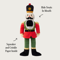 Load image into Gallery viewer, Same view of the nutcracker toy, with added text which reads: "hide treats in mouth" and points to its mouth, and "squeaker and crinkle paper inside" and points to its body.