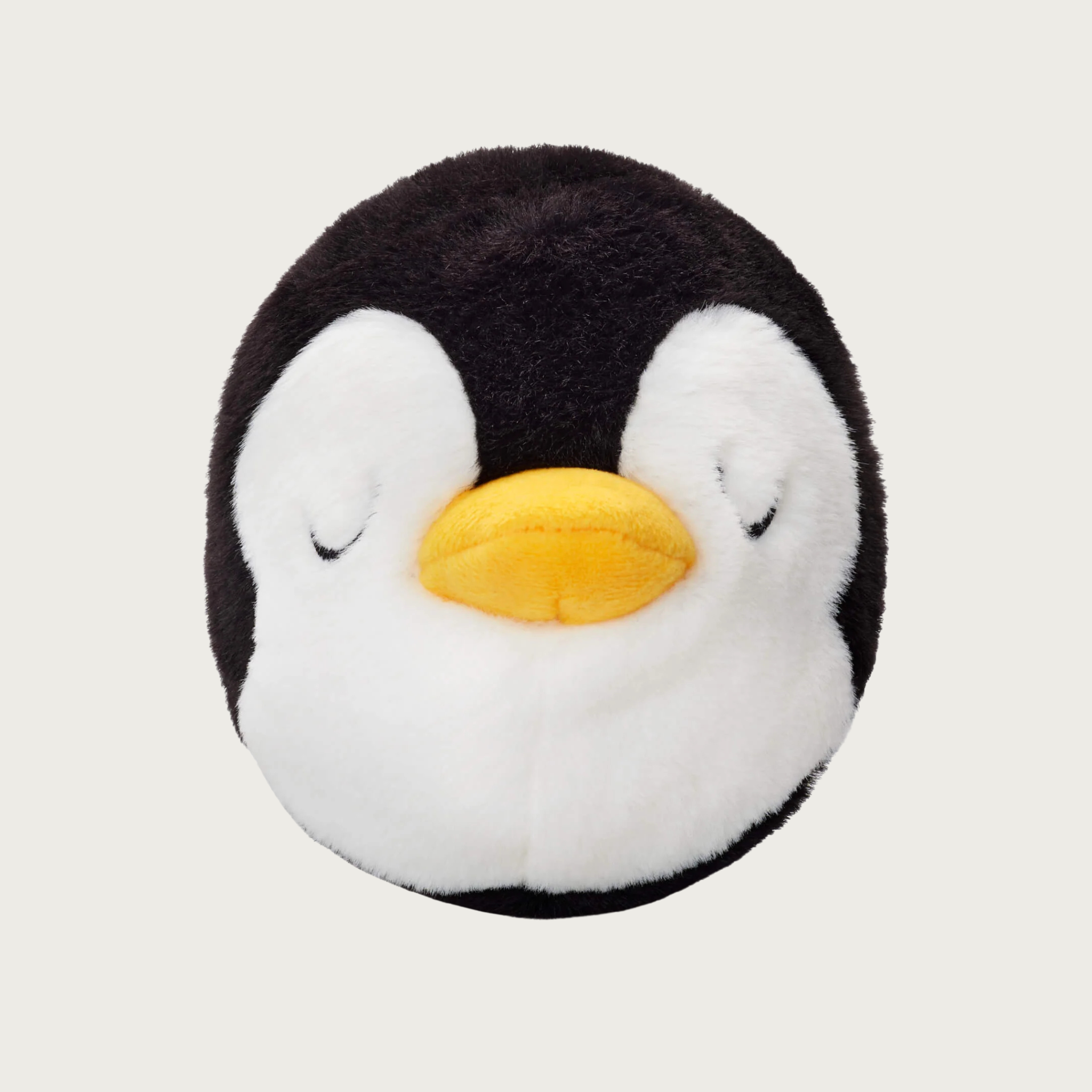 Plush penguin ball dog toy with a yellow beak and sleepy, embroidered eyes.