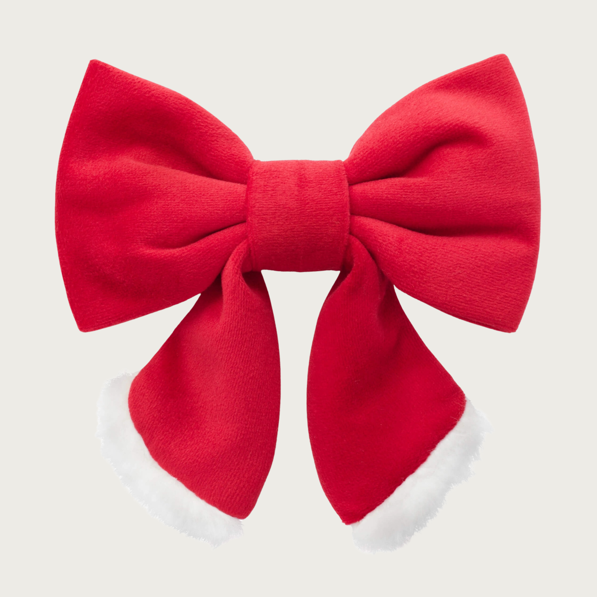 Christmas-themed, red velvet and white plush dog lady bow by The Foggy Dog. Looks like a hair bow for a person, with the center bow tie and ends hanging down. Body of the bow is red, with the tips of each end accented with the white plush fabric.