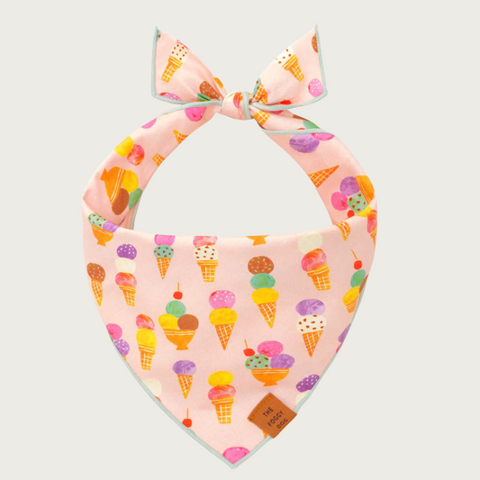 Dog bandana with multicolored pastel ice cream cone pattern on a pink background.