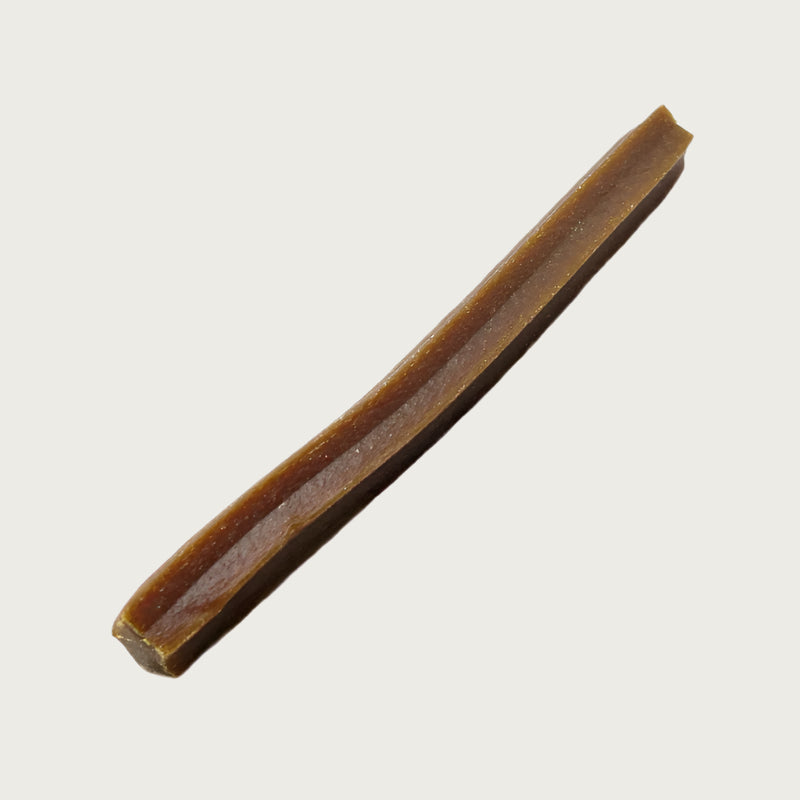 Brown dog chew stick with wide ridges along its length.