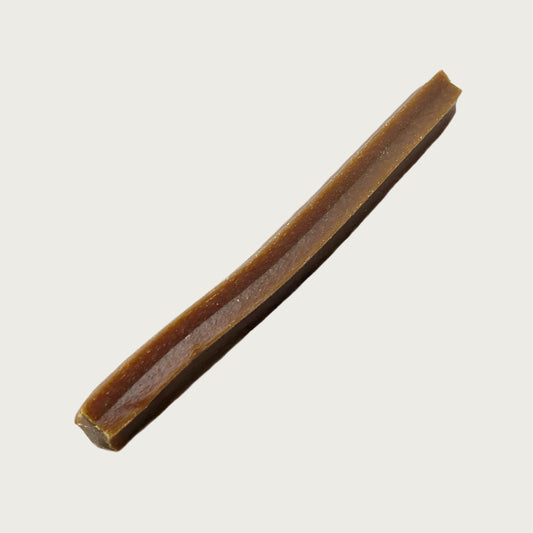 Brown dog chew stick with wide ridges along its length.
