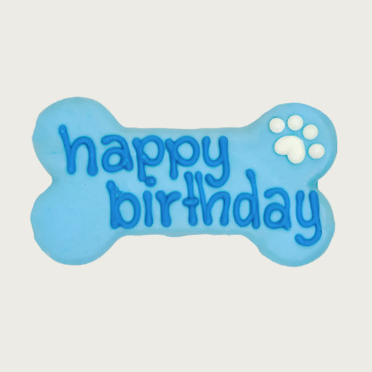 Blue bone-shaped dog cookie with 'happy birthday' text in darker blue, with white paw print accent.