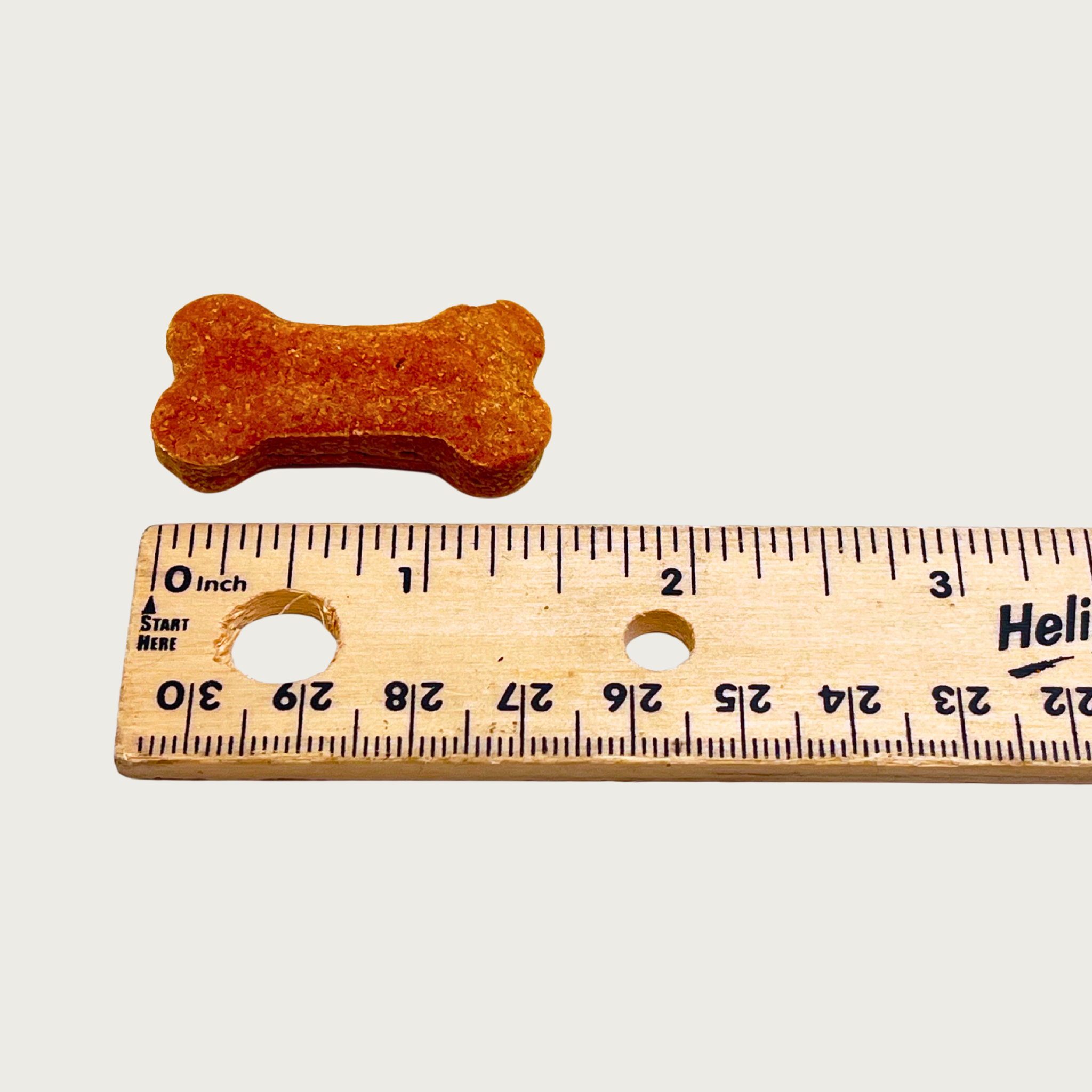 One bone treat next to a ruler to show size. It is just under 1.5" long.