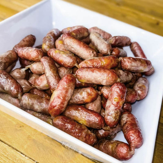 A square white bowl filled with mini cheddar brats for pets.