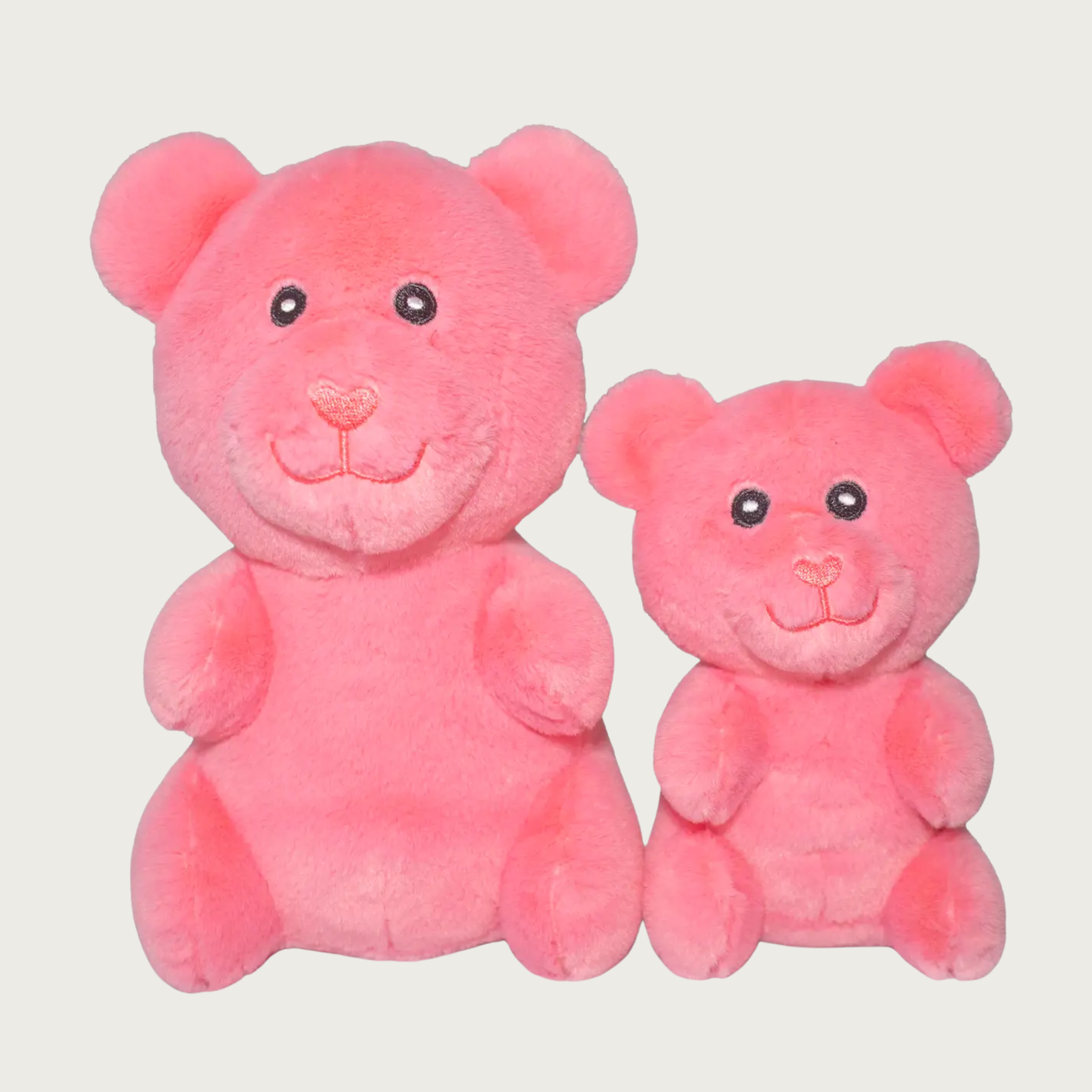 Two plush salmon pink gummy bear shaped dog toys, side by side to show size difference.