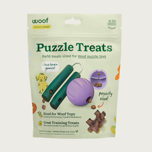 Green bag of Woof Puzzle Treats, refill treats sized for Woof puzzle toys (Nomchucks, Flyball & Walkabout). Great training treats-bite-sized morsels for good boys & girls. Their Nomchuck and Walkabout toys are featured, and show the treats coming out of them. Small, clear window shows the tiny brown treats inside.