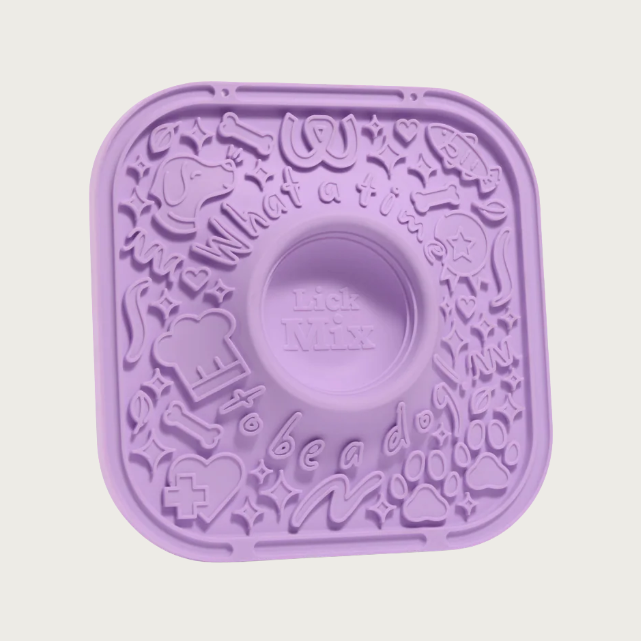 Lavender silicone lick mat for dogs, with raised, dog-themed graphics on the surface to hold spreads. In the center is a deep, round indentation to be used for mixing treat ingredients together.