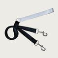 Load image into Gallery viewer, Dog leash with light gray loop handle with D-ring at its other end. The main part of the leash is black, and feeds through the D-ring on the handle. Each end of the black leash has a metal clip.