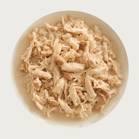 A bowl of Aujou by RAWZ Chicken Breast & Duck recipe, showing large chunks of chicken with smaller shreds and small pieces of duck.