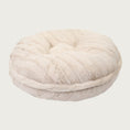 Load image into Gallery viewer, Side view of the Bagel Bed in Cream Mink. A ring of fabric goes along the center edge of the bed, hiding the zipper.