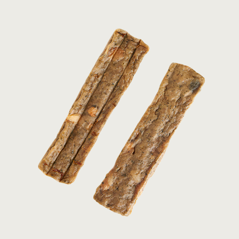 Two side-by-side sample pieces of Dogswell Dental Jerky. Tan in color.