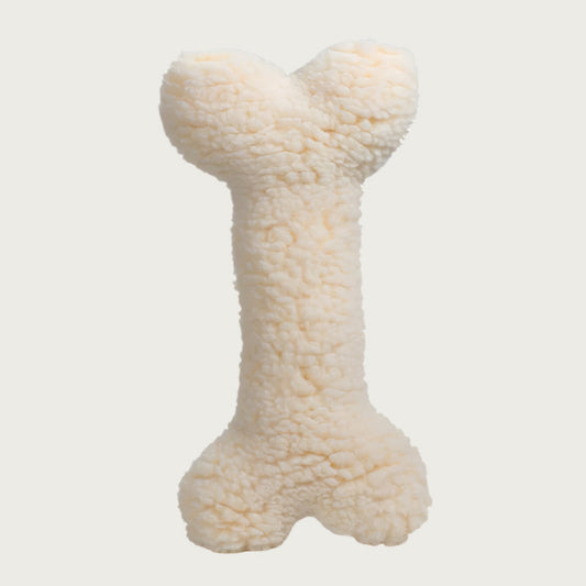 Reverse side of the Tartan Tidings Bone dog toy. It is solid cream colored, faux lambswool.