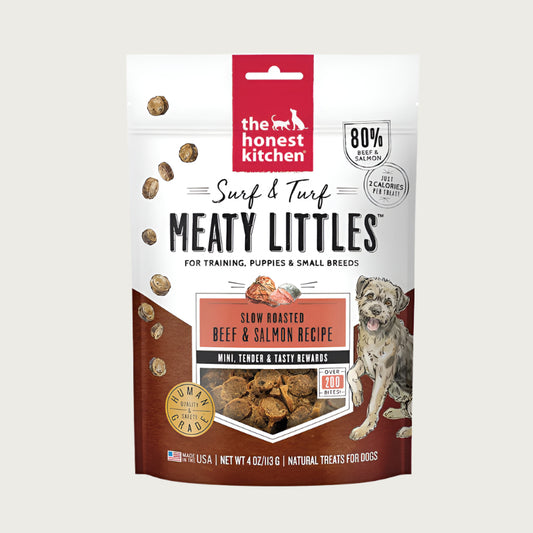 4 oz bag of Surf & Turf Meaty Littles from The Honest Kitchen, slow roasted beef & salmon recipe dog treats. 80% beef & salmon, just 2 calories per treat. Mini, tender & tasty rewards. Over 200 bites per bag. Human grade. Small transparent window on front shows product inside: small, reddish brown bites.
