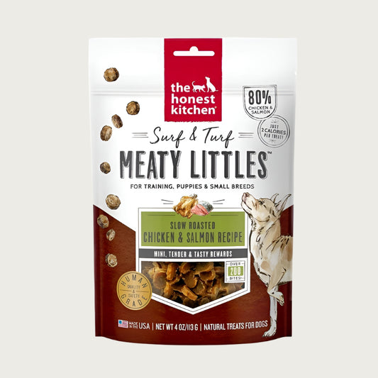 4 oz bag of Surf & Turf Meaty Littles from The Honest Kitchen, slow roasted chicken & salmon recipe dog treats. 80% chicken & salmon, just 2 calories per treat. Mini, tender & tasty rewards. Over 200 bites per bag. Human grade. Small transparent window on front shows product inside: small, reddish brown bites.