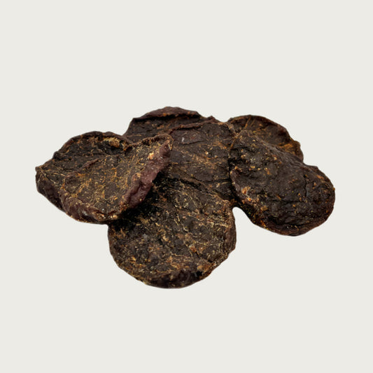 Loose pile of beef sliders. They are round and dark brown.