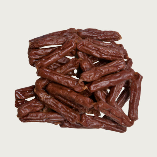 Close-up photo of a small stack of Wet Nose Beef Smokies dog treats. They are reddish brown links, measuring about 2.5" long.