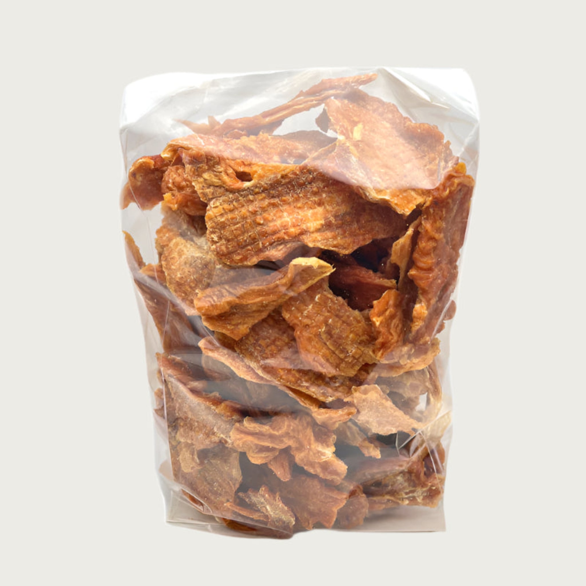 2 lb clear cellophane bag of Wet Nose exclusive Chicken Strips dog treats, tied with black ribbon. Inside are strips of chicken tenders, that are pale orangey-tan in color.
