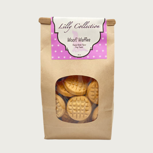 16 oz brown craft paper bag of Wet Nose Lilly Collection Woof! Waffles Peanut Butter Flavor Dog Treats. Clear window on bag shows tan, round and flat, cookies inside.