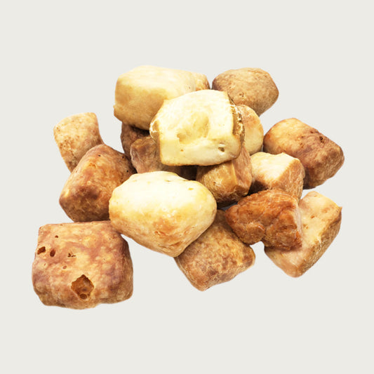 Cluster of beige to tan colored milk bone puffs, to show variations in size and color.